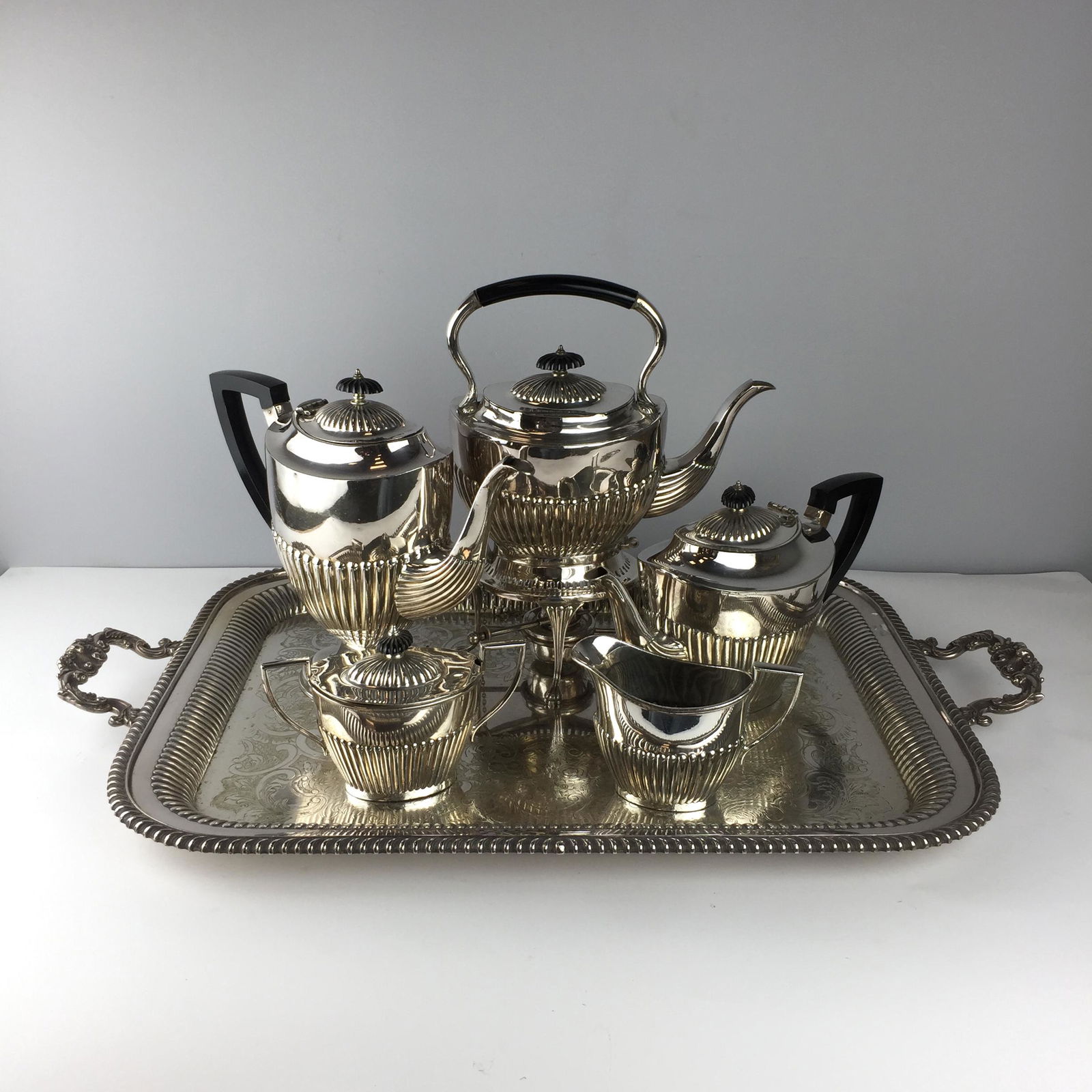 English Queen Anne style silver plated metal serving: English Queen Anne style silver plated metal tea and coffee serving set, with black bakelite handles and knobs. Comprising samovar, coffee pot, teapot, sugar bowl with lid, milk jug and rectangular tr