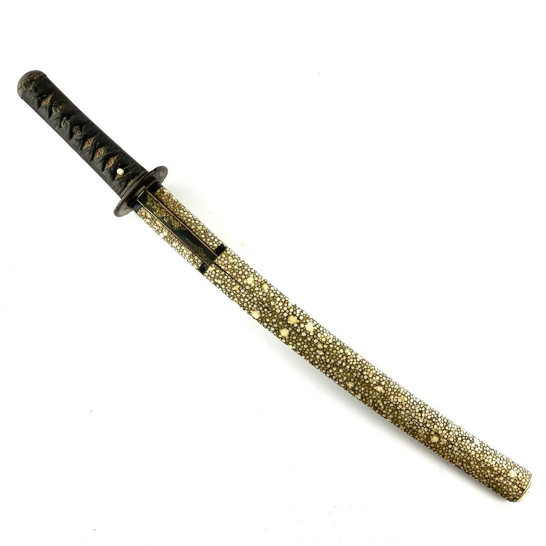 Katana: Katana. Handle lined in stingray leather with original stringing. Menukis in bronze. Tsuba in iron with gold inlay. Sheath lined in stingray leather and miniature knife with inscription on blade. hand
