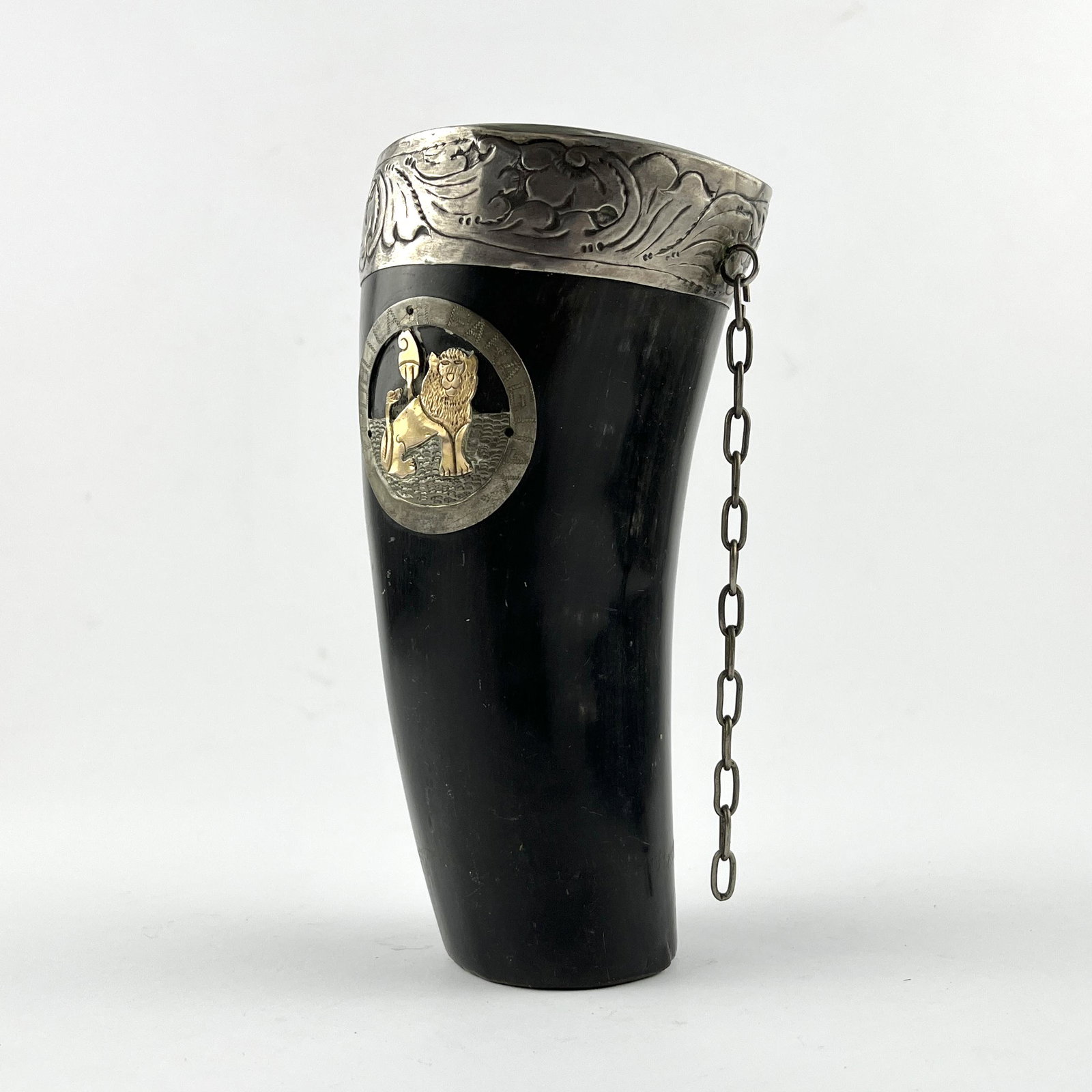 Chambao in guampa and silver: Chambao in guampa with chiselled silver ferrule "leaves", decorated "Paraguayan coat of arms" in gold and silver, with chain. Height 15.5 cm.Chambao en guampa con virola en plata cincelada "hojas", de