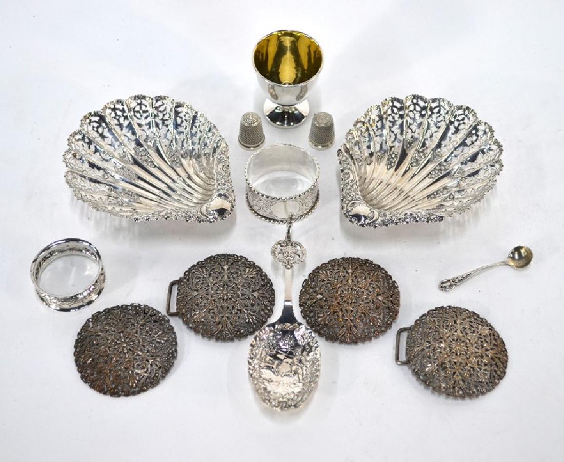 A collection of silver items including a pair of bonbon: A pair of pierced silver shell bonbon dishes, on reeded bun feet, Atkin Bros., Sheffield 1911, to/w an egg cup, two napkin rings, two thimbles (one by Charles Horner, Chester 1902), and a salt spoon;