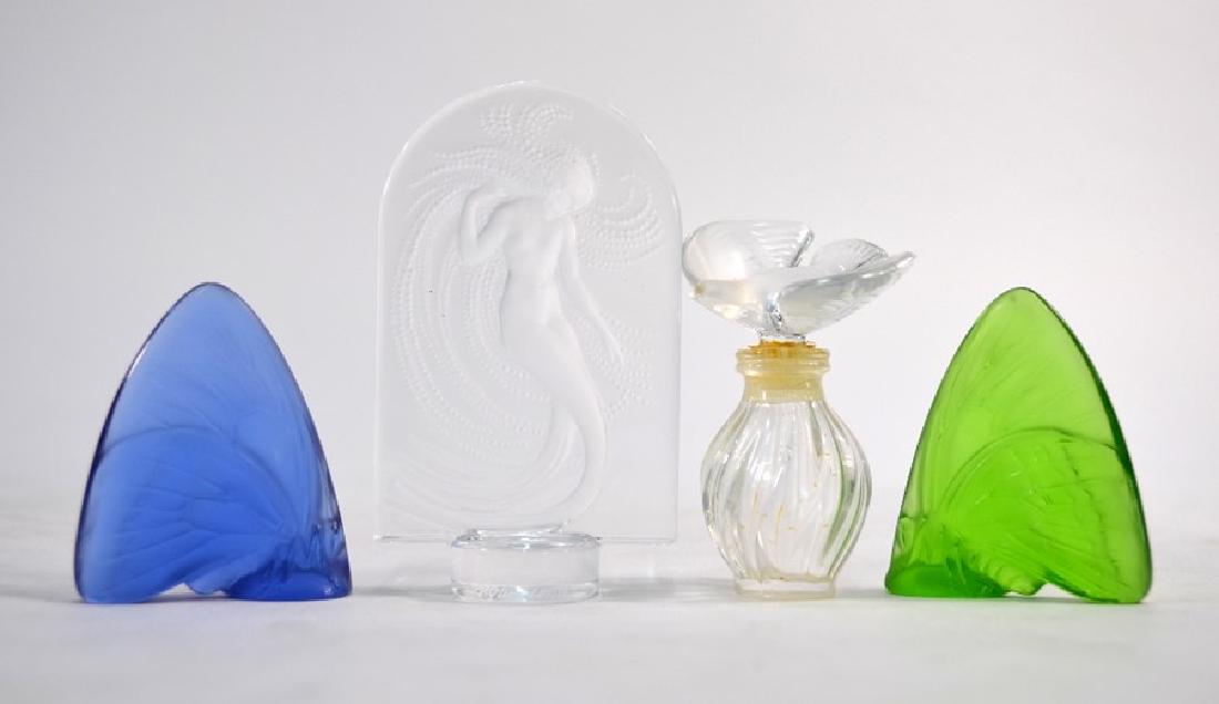 Four Lalique items: Two Lalique models of butterflies, one blue glass and the other green glass, 5.8 cm high to/w a Lalique perfume bottle, 7.4 cm high and a Lalique cameo glass plaque depicting a woman with long tresses