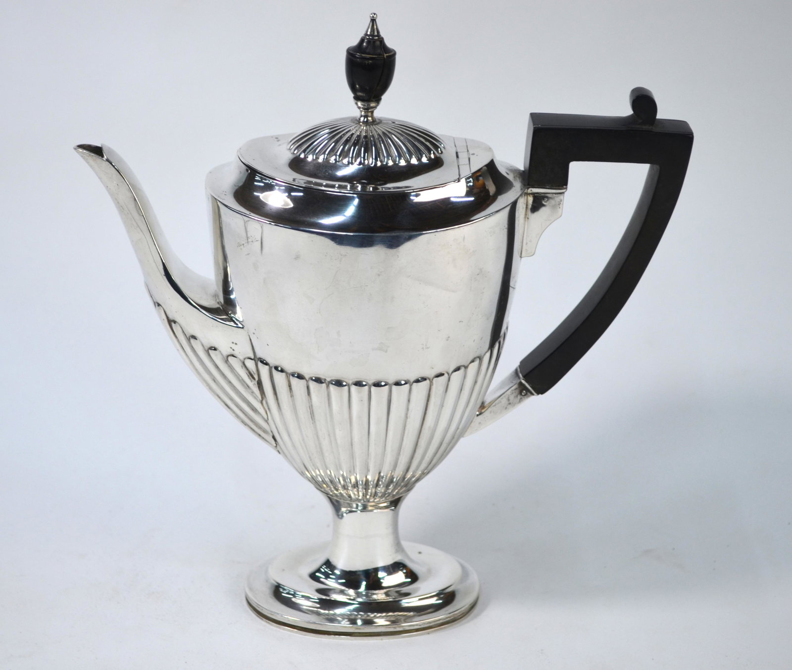 Edwardian coffee pot: An Edwardian silver half-reeded coffee pot in the Adam manner, on oval stemmed foot, with ebonised urn finial and composite handle, London 1907, 18.9 oz gross