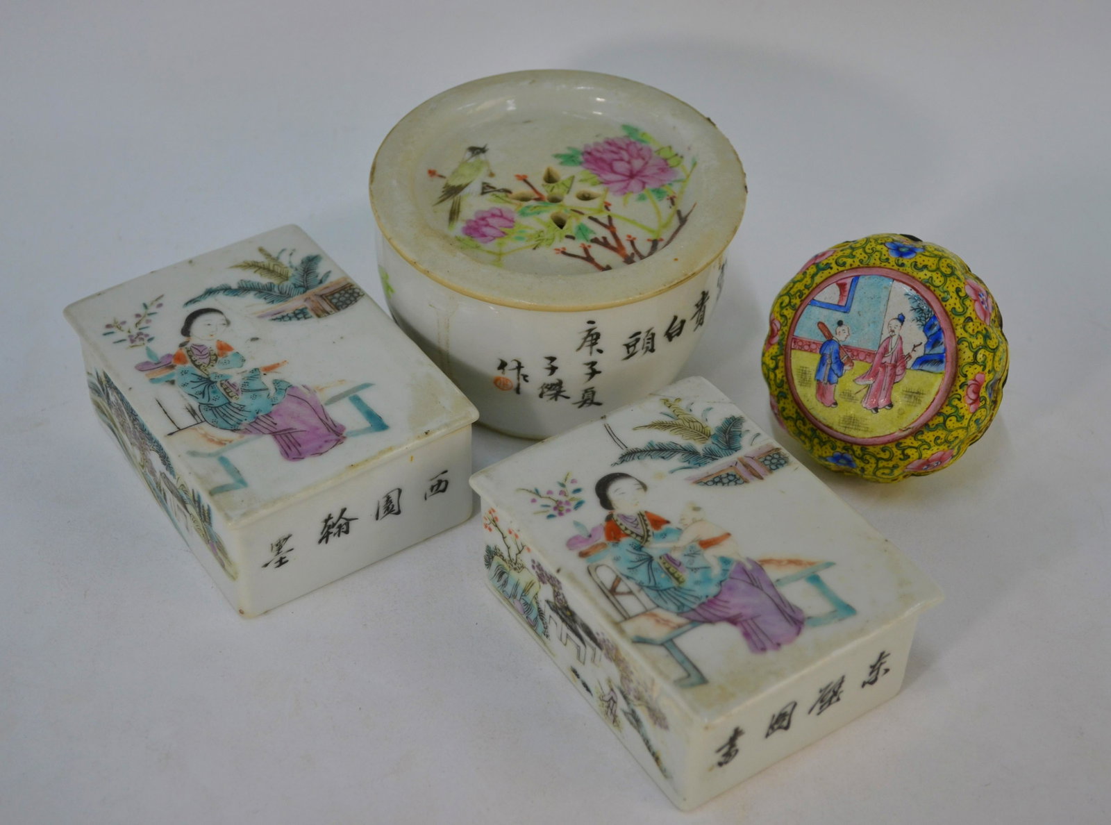 Three Chinese famille rose boxes and a Canton yellow: Two Chinese porcelain famille rose rectangular boxes and covers, painted with figures in a garden setting and four character inscriptions in black to/w a circular famille rose box and cover painted wi