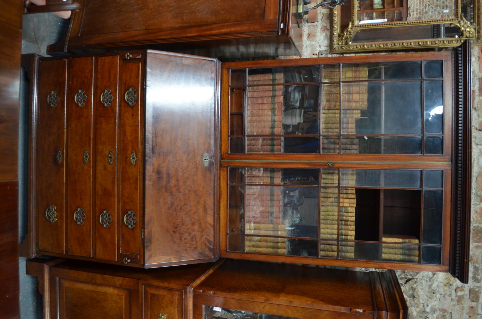 A George III mahogany bureau bookcase: A George III mahogany bureau bookcase, the dentil moulded cornice ovar a pair of astragal glazed cabinet doors enclosing adjustable shelves and three drawers, the fall with fitted interiors over four 
