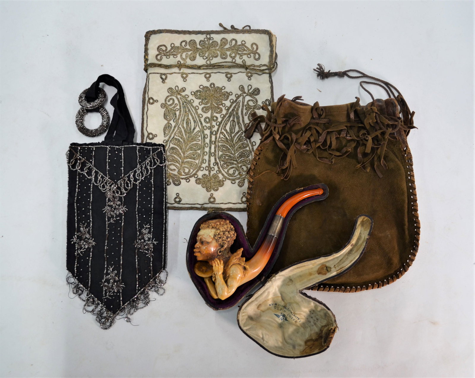 A 19th century Austrian Meerschaum pipe and other items: A 19th century Austrian Meerschaum pipe, carved as a blackamore head with crab on a plate, with Withecoms Patent white metal screw and amber stem, the case for Franz Hiess, Vienna to/w a Persian white