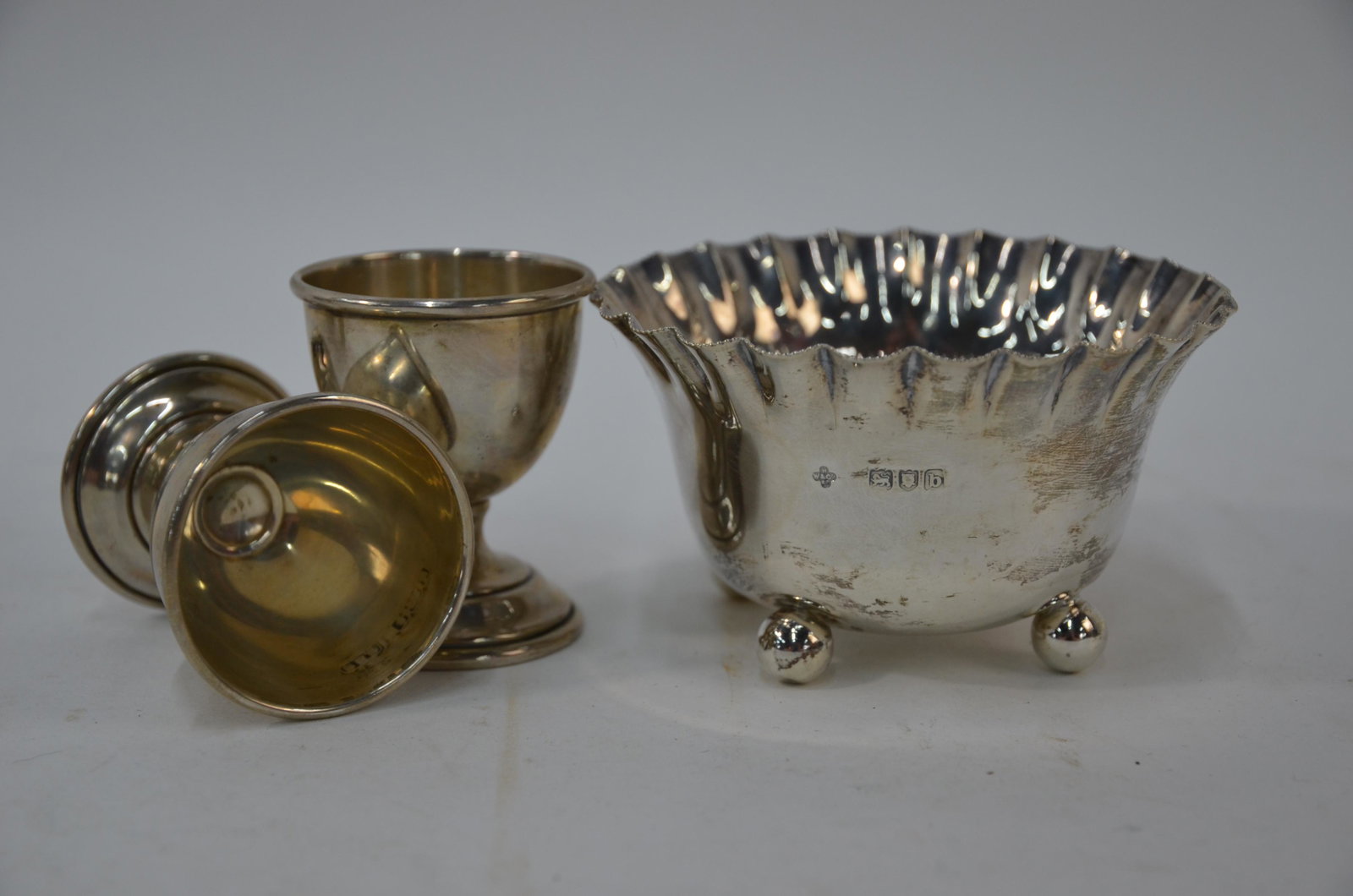A silver 'Hatching Chick' pin cushion and other silver: A silver 'Hatching Chick' pin cushion, London 1997 to/w a bottle-stopper surmounted by a horse, London 2005, a miniature pig stamped 925, a pill box surmounted by a 'happy pig', London 2000, a late Vi