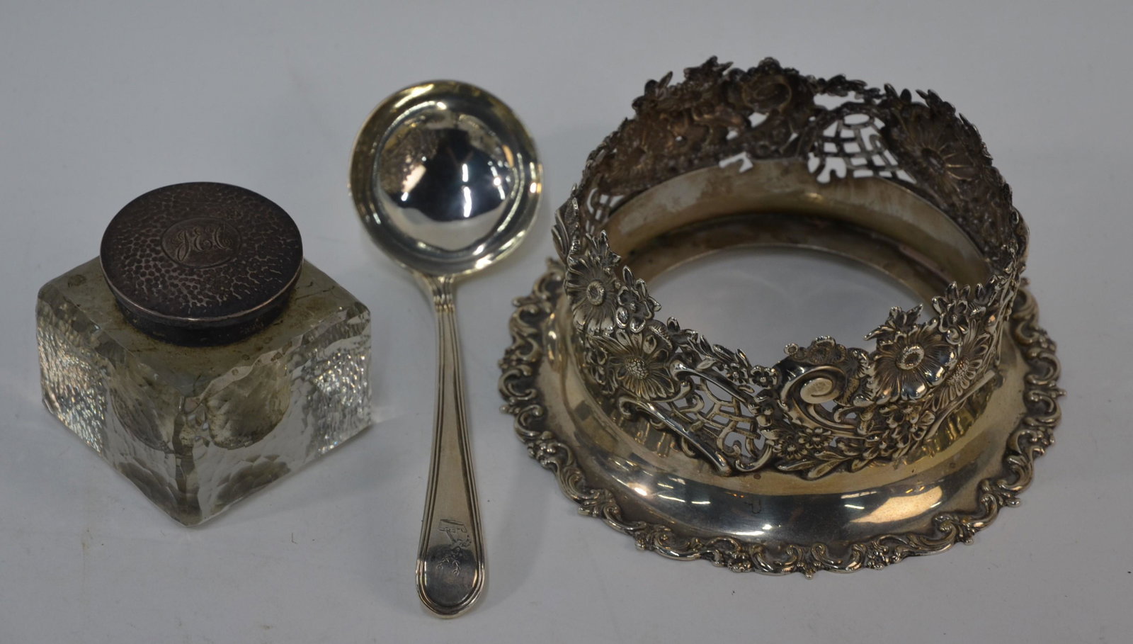 US Sterling syphon-stand, Georgian sauce ladle and: A US Sterling syphon-stand, richly chased, embossed & pierced with floral decoration, Redlich & Co, New York, 15 cm diam. to/w a Georgian thread pattern sauce ladle, London 1795 and an Edwardian squar