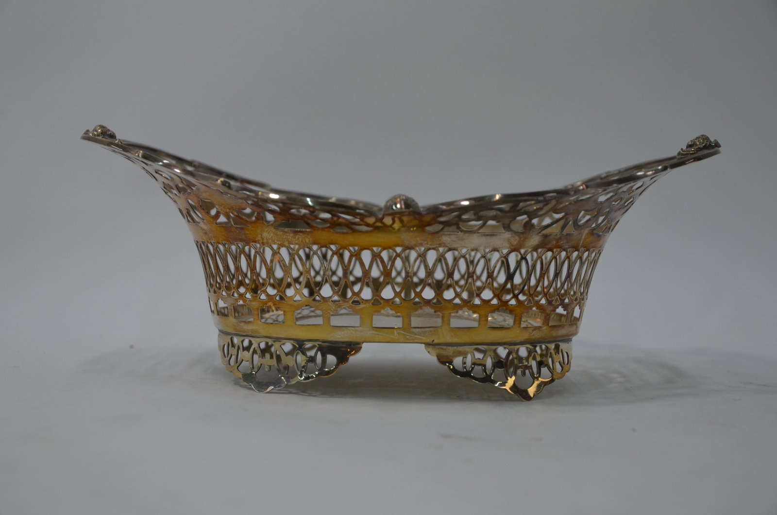 An Edwardian Sheraton revival pierced silver bonbon: An Edwardian Sheraton revival pierced silver bonbon basket with cherub mask-set scrolling rim, W & C Sissons, London 1901, 6.8 oz