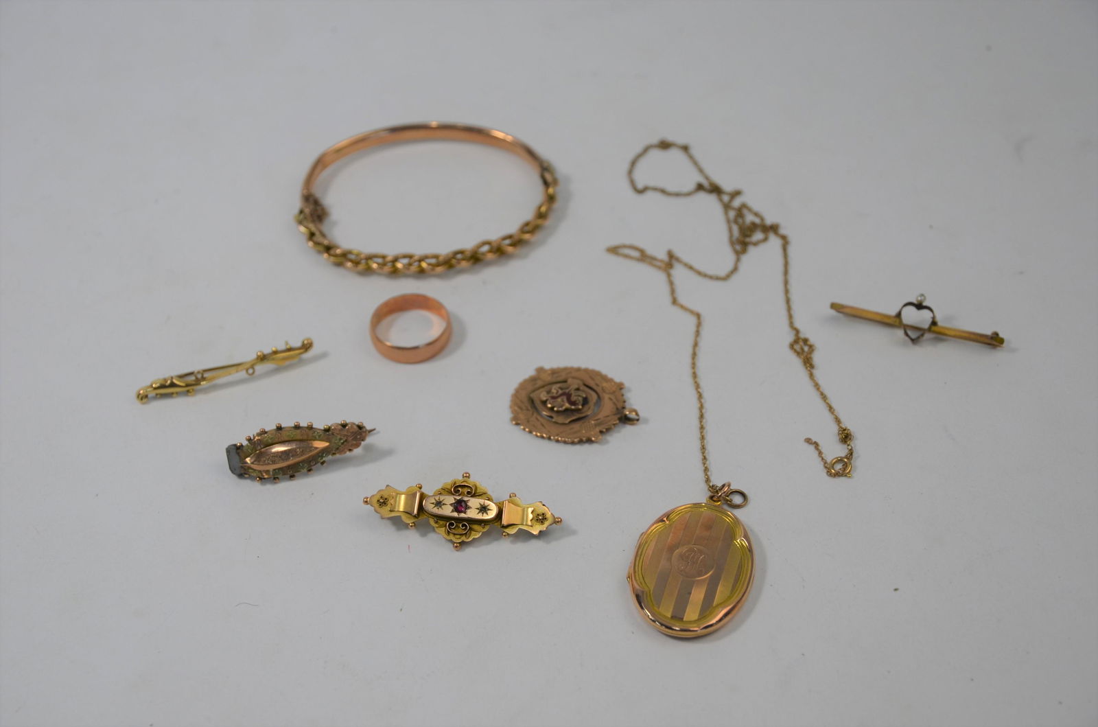 A collection of 9ct old gold items: A collection of 9ct old gold items including a yellow gold medal, four Victorian brooches, oval locket, oval half hinged bangle with rope twist decoration and a wedding band, approx 31g all in, a/f