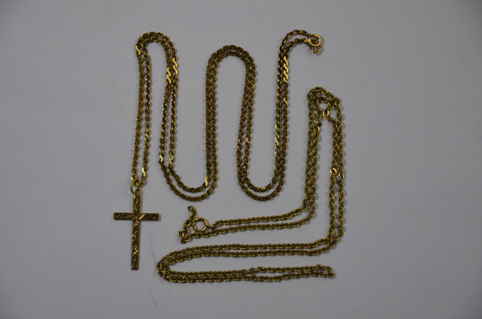 A 9ct yellow gold cross on a 9ct yellow gold fancy link: A 9ct yellow gold cross on a 9ct yellow gold fancy link chain, approx 11.3g to/w another unmarked and untested chain (2)