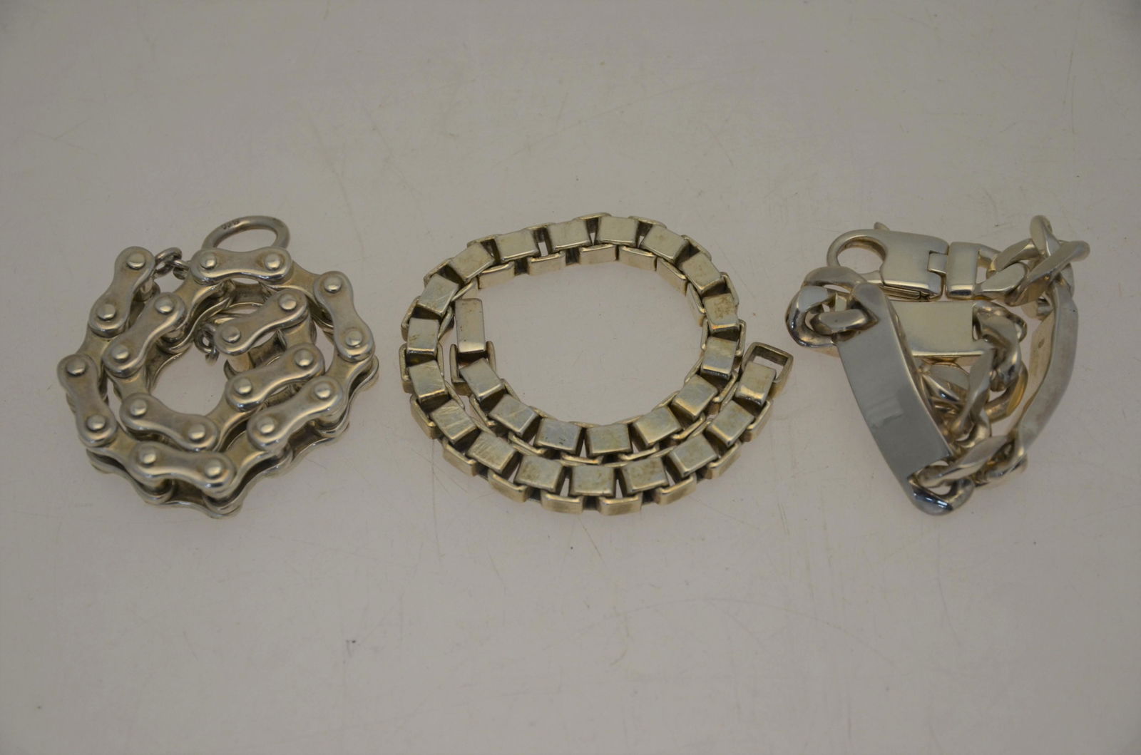 Two various silver and white metal heavy curb and: Two silver and white metal heavy curb and square link bracelets, 20.5 cm and 22.5 cm long, approx 126.2g