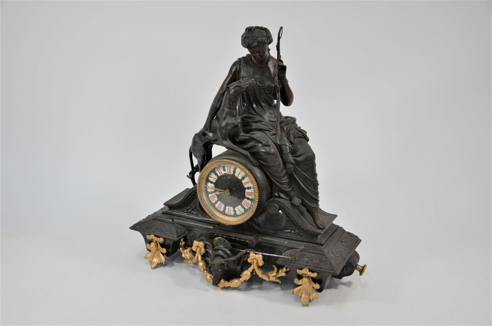 A 19th century continental bronzed spelter mantel clock: A 19th century continental bronzed spelter mantel clock, the two train drum movement surmounted by a seated 'Diana the Huntress' and hound 46 cm high overall