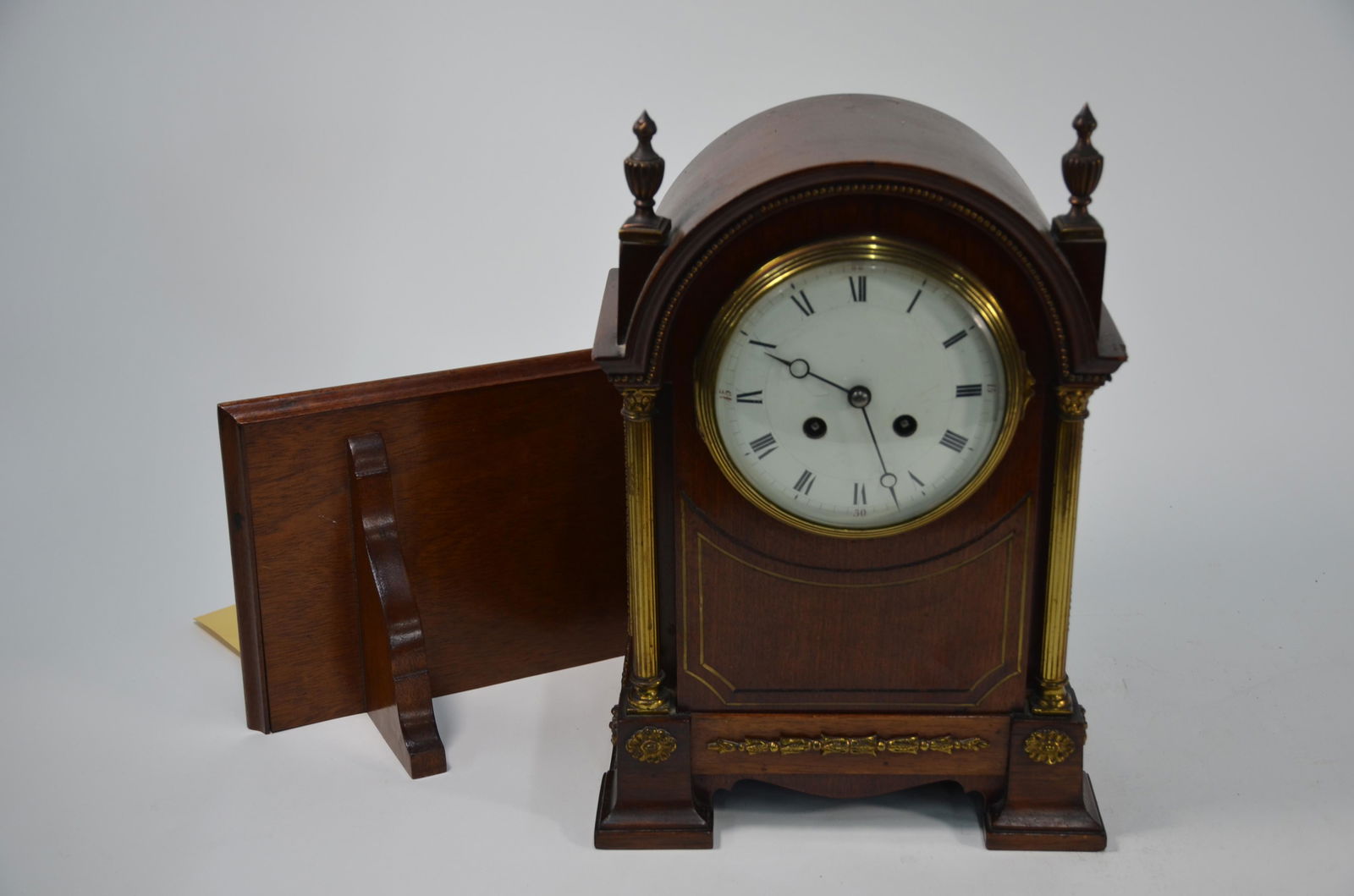 A gilt-metal mounted mahogany bracket clock: A gilt-metal mounted mahogany bracket clock, the two train eight-day French movement striking on a coiled gong, with white enamelled dial, to/w wall bracket 32 cm high overall
