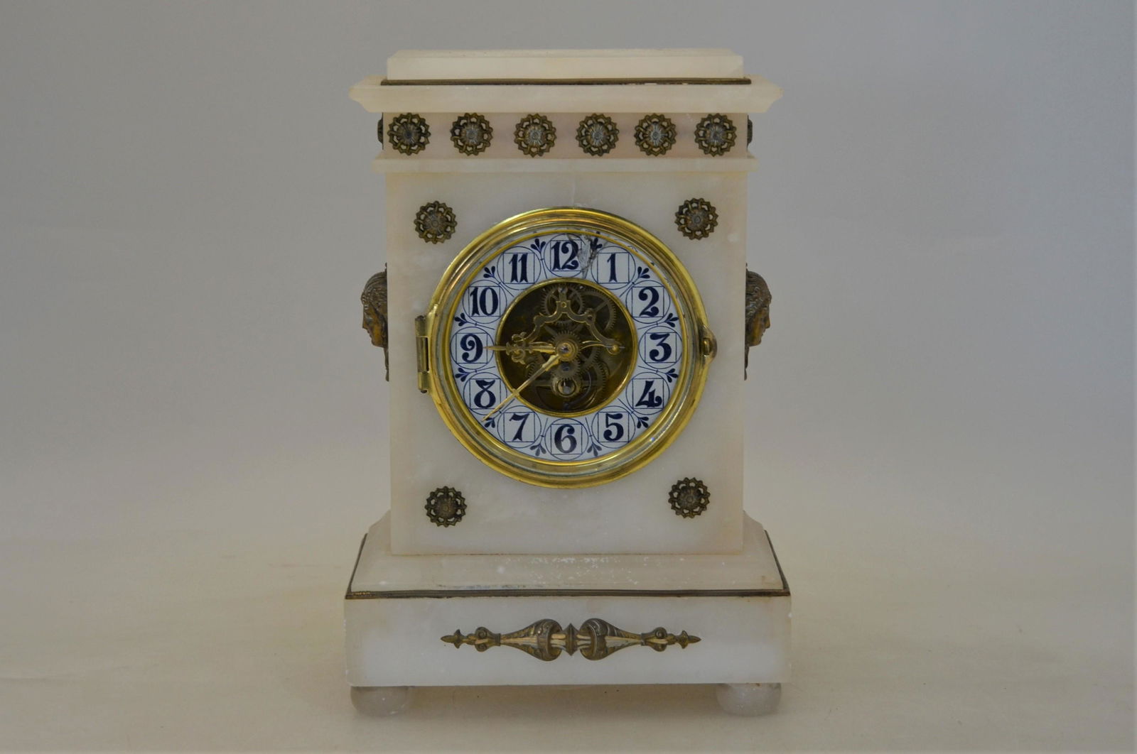 A late 19th/early 20th century gilt metal mounted: A late 19th/early 20th century gilt metal mounted alabaster mantel clock, the eight day movement signed Farcot, Paris with blue and white enamelled dial, 30 cm high