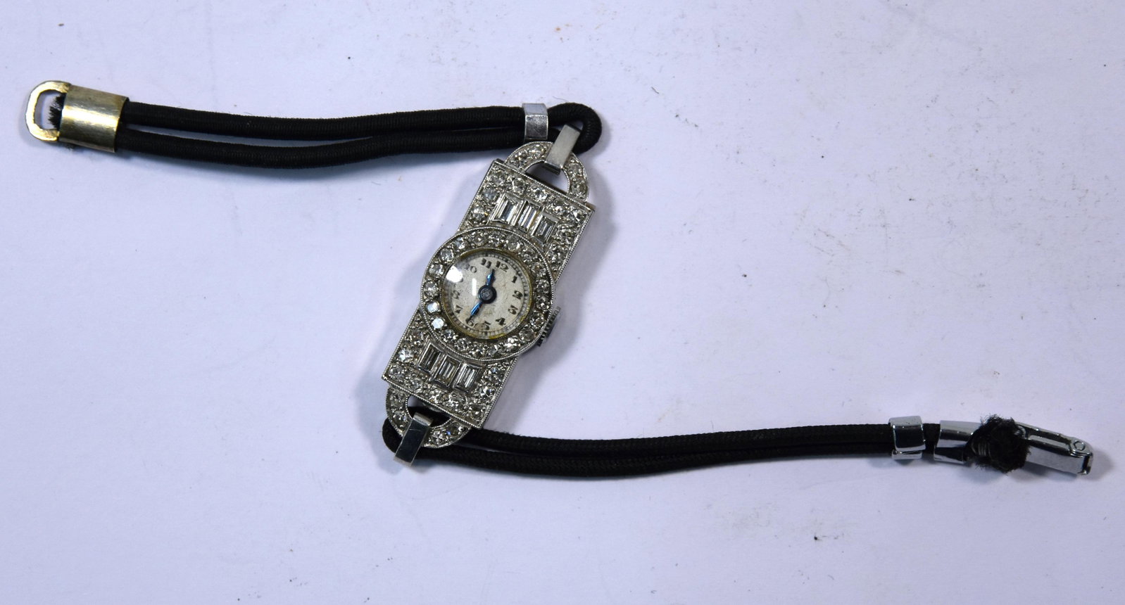 Art Deco platinum and diamond cocktail watch: An Art Deco platinum and diamond cocktail watch, set with brilliant-cut and baguette stones, Swiss movement, on woven silk cord strap