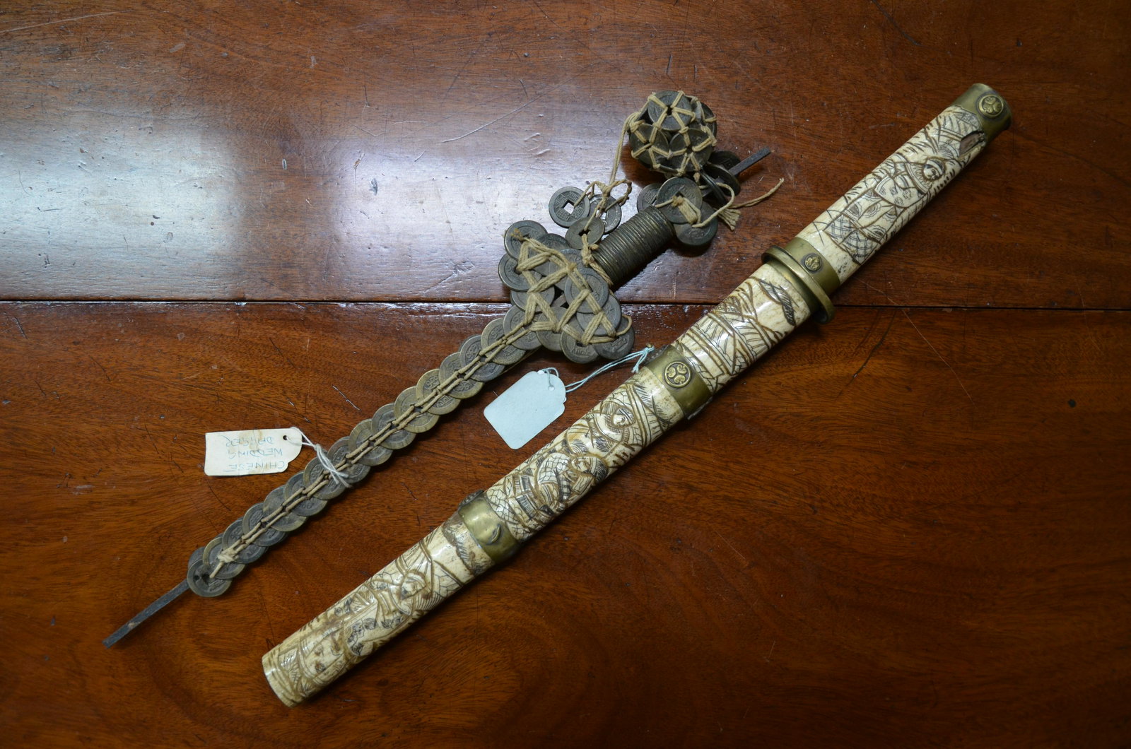 A Japanese bone and brass bound wakizashi to/w a: An early 20th century Japanese short wakizashi, 32 cm blade, sectional bone and brass bound tsuka (handle) and saya (scabbard) profusely carved with landscapes and figures, 48 cm o/a to/w a 19th centu
