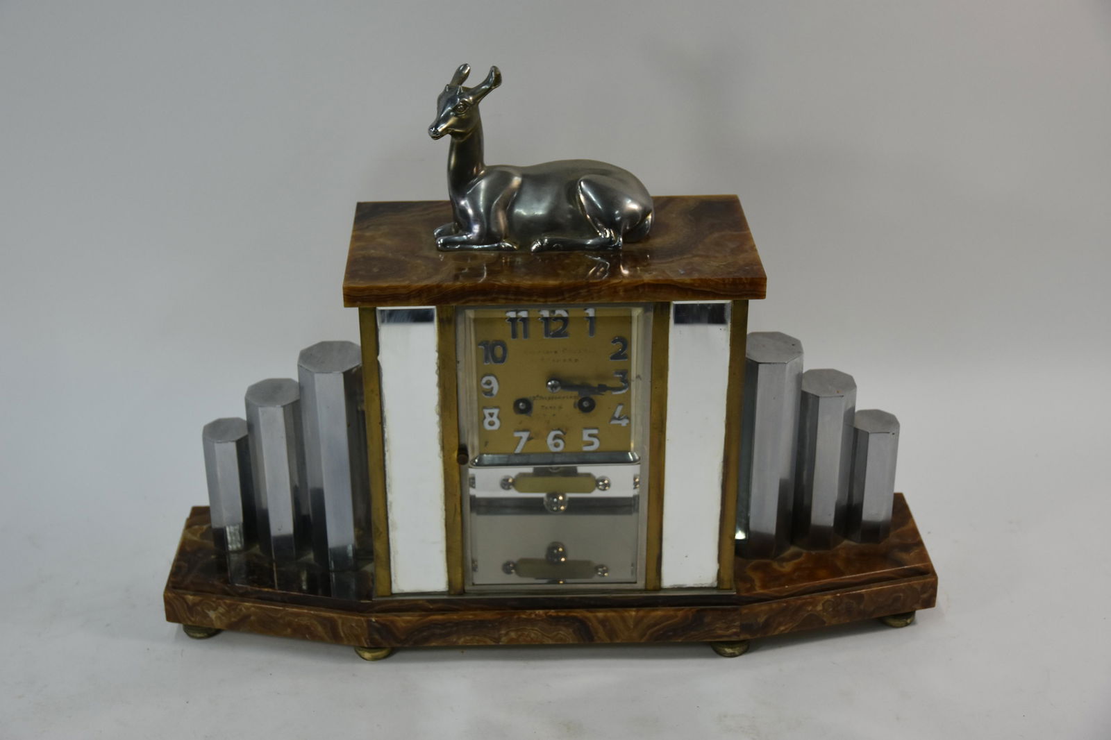 A French Art Deco mantel clock,: A French Art Deco mantel clock, with eight day two train movement striking on a bell, the stylish marble case with chromium plated mounts and surmounted by a reclining deer, 48 cm x 36 cm h