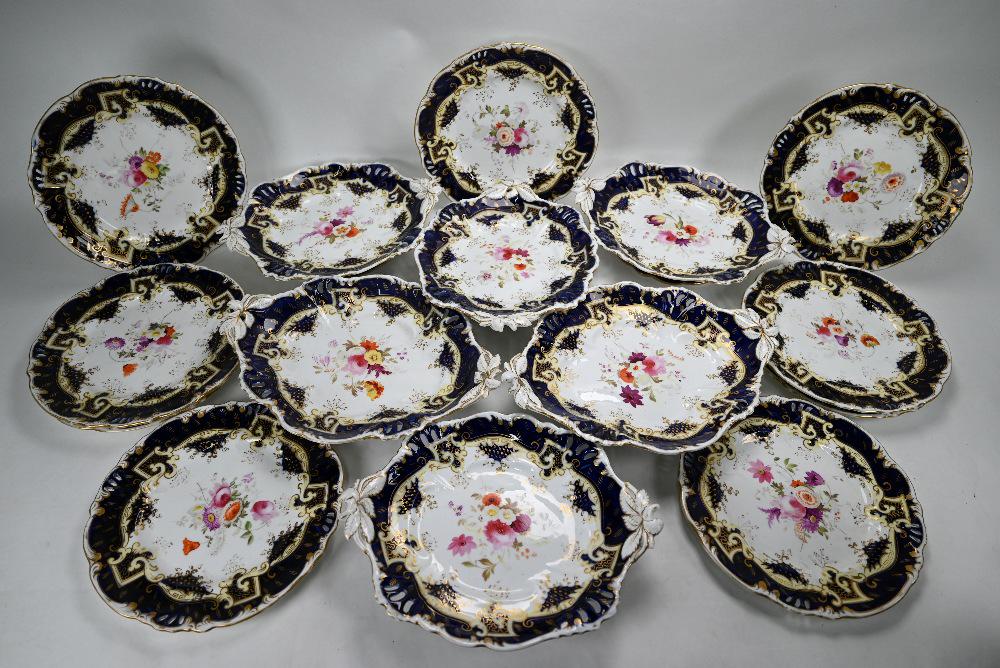 Victorian floral-painted fruit service: A set of six early Victorian china stemmed dishes with foliate-embossed twin handles, painted with floral sprays within a cream, blue and gilt border, 29cm wide, to/w nine matching 23.5cm plates (15)