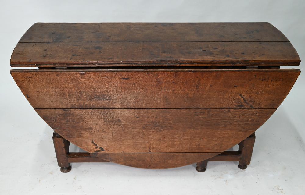 An antique oak gateleg supper table: An antique oak gateleg supper table, the oval top raised on turned and block joint frame, drawer to one end, 136 cm long (53 cm closed) x 168 cm wide x 72 cm high