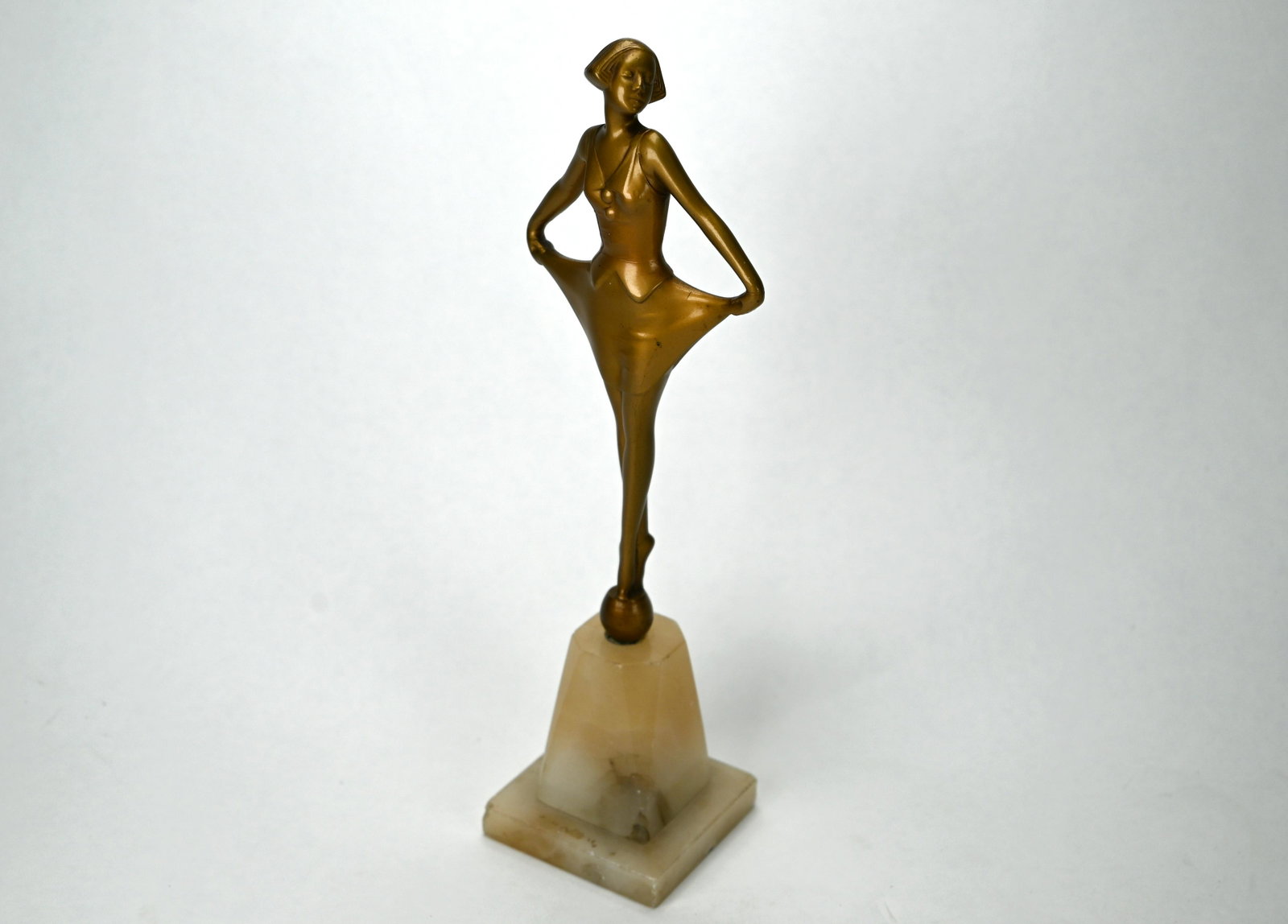 A 1930s Art Deco gilt-patinated figure of a female: A 1930s Art Deco gilt-patinated figure of a female dancer 'en pointe', on alabaster base, 28 cm high overall