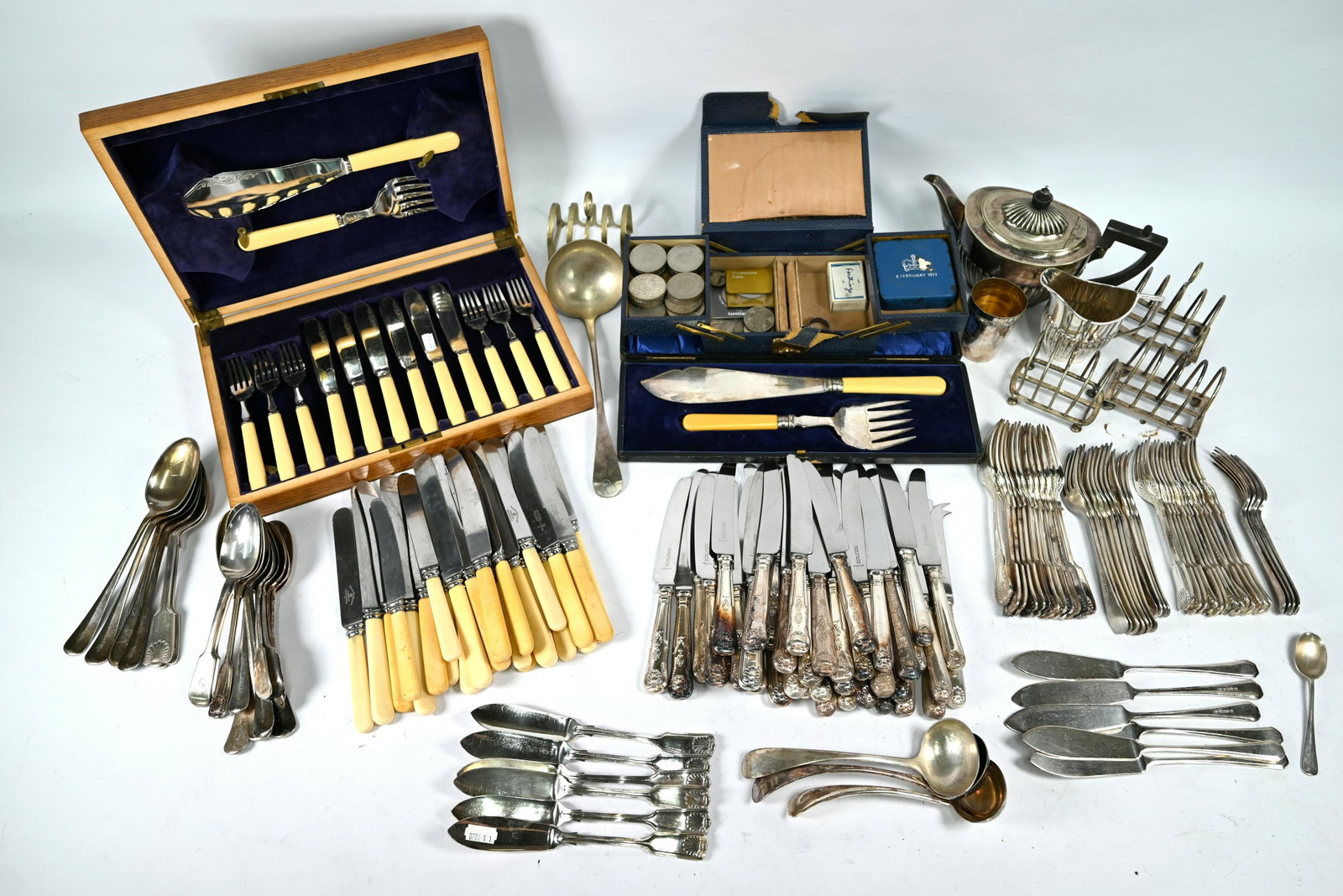 A quantity of fiddle, thread and shell flatware and: A quantity of fiddle, thread and shell flatware and cutlery, to/w various other mixed flatware, half-reeded bachelor teapot and milk jug, a collection of Churchill and other commemorative crowns (incl