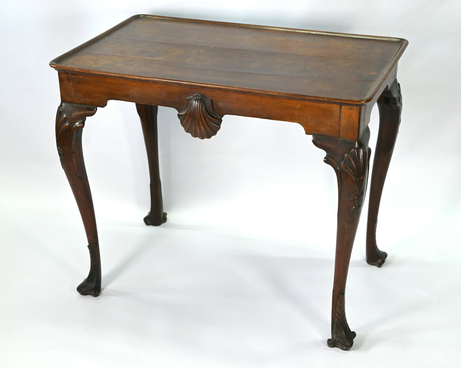A George III mahogany shell carved silver table of: A George III mahogany shell carved silver table of Irish origin, the rectangular top with raised lip, on cabriole legs to moulded toes, 85 cm w x 52.5 cm x 71.5 cm h, Provenance: Hamwood House, County