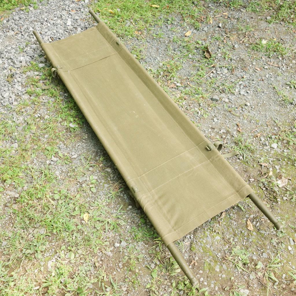 US Army Stretcher: Canvas stretcher with wooden carrying poles. "Orthopedic Equipment Co. Inc. Bourbon Ind." written on canvas. 90 1/2"x21 1/2"