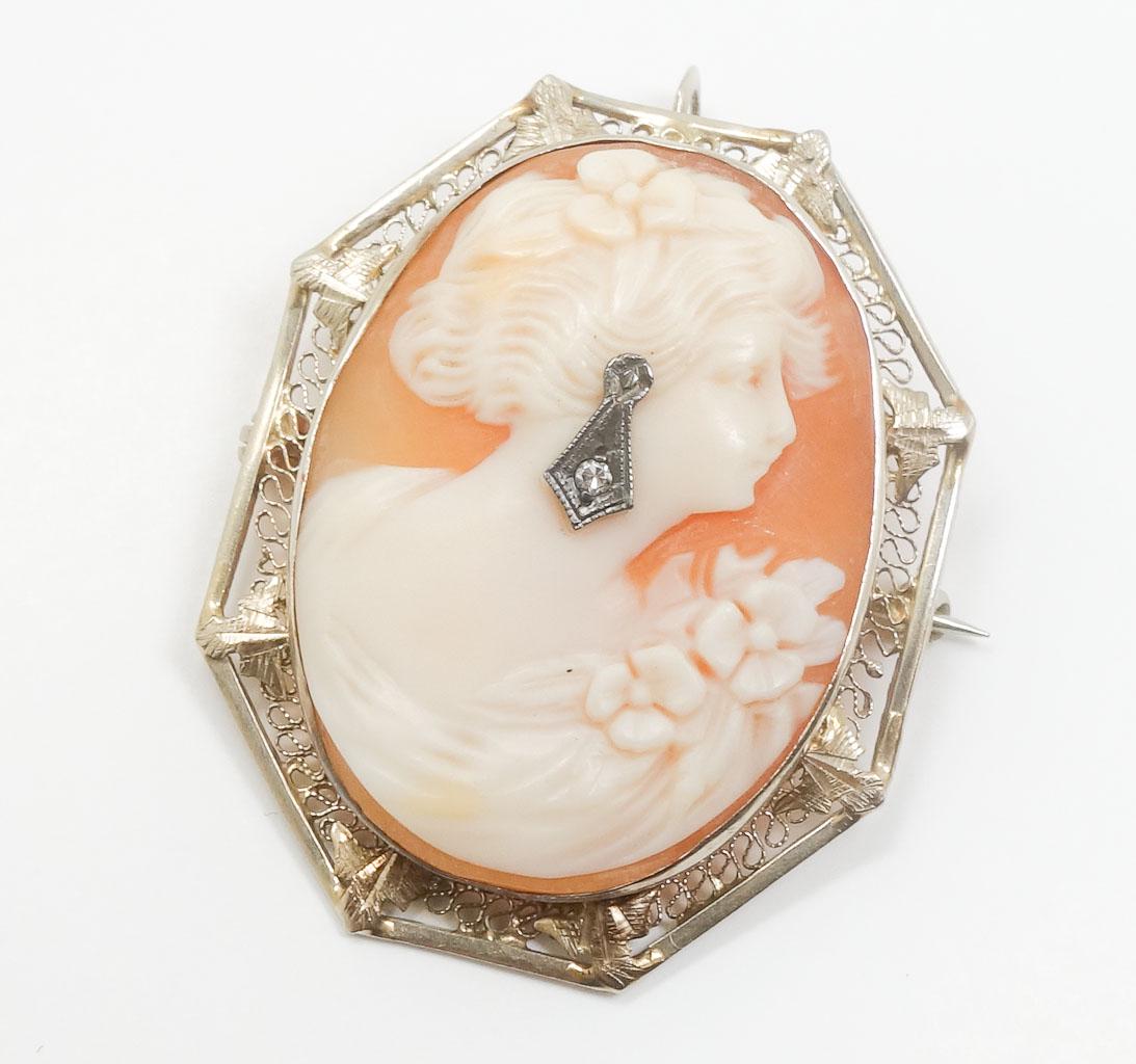 14k Carved Shell Cameo Brooch Woman w Diamond Earring: This is an antique cameo brooch pin dating to around the turn of the century. Rendered in fine 14k yellow gold, this filigree frame features a carved shell cameo of a woman with a single cut diamond e