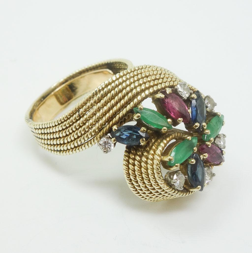 Vintage MCM Jack Gutschneider 14k Yellow Gold Ring: This is a vintage MCM Jack Gutschneider ring. Rendered in fine 14k yellow gold, it features an array of cut emeralds, rubies, sapphires and diamonds. This ring has a sizer installed. It is stamped "JG