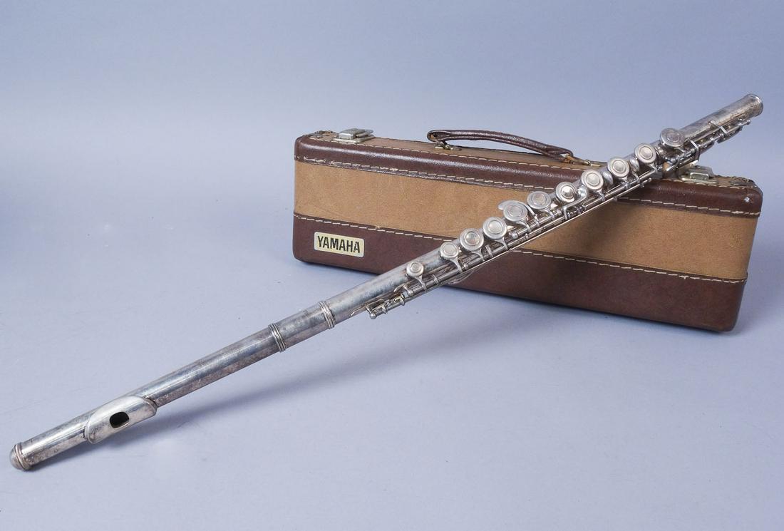Yamaha Silver Flute Model YFL-24S: Silver Yamaha brand flute with hard case. The flute is stamped "Yamaha YFL 24S Japan" and bears the Yamaha logo. This flute comes with a cleaning rod. Case: 17"x5"x3" Length of flute assembled: 26 1/2