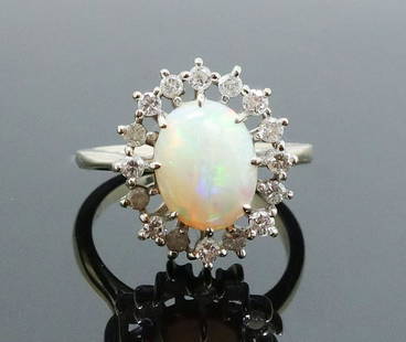 Fine Play of Color Australian Opal 18K Diamond Ring: This is a beautiful estate found vintage opal ring. Rendered in fine 18k white gold, it features 16 full cut diamonds surrounding an Australian opal with fine play of color. The inside of the ring is