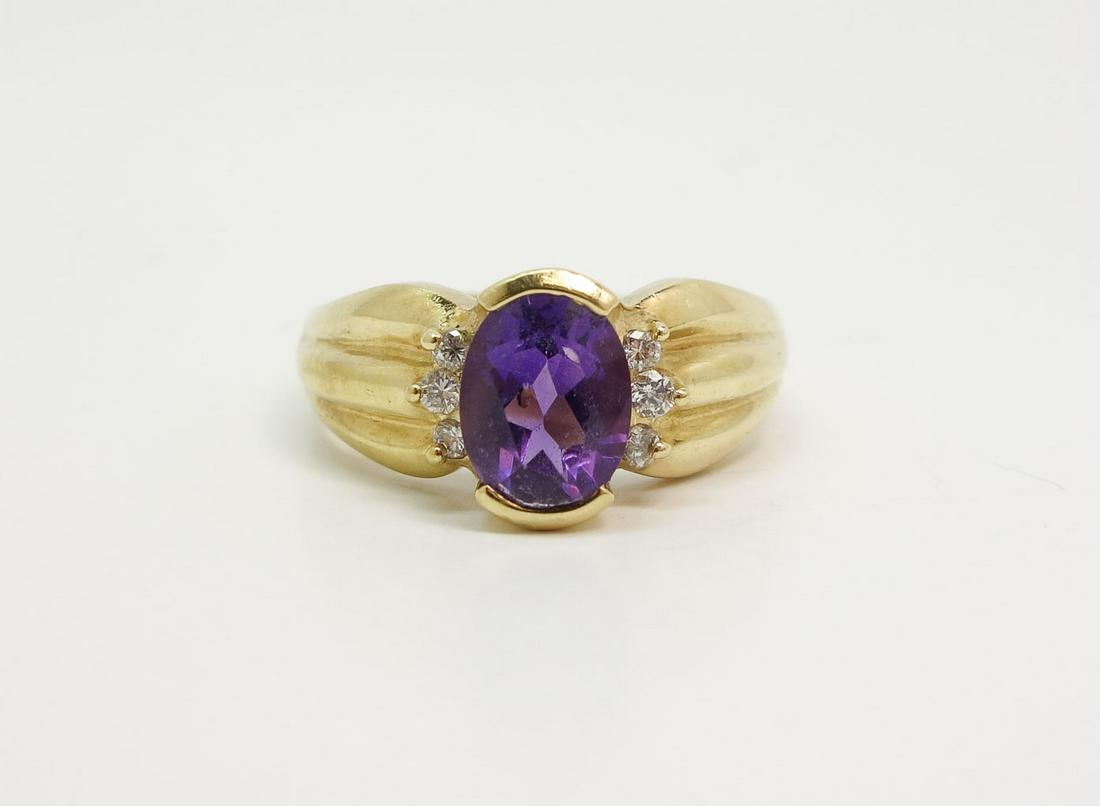 18K Yellow Gold Oval Amethyst Diamond Ring: This is a beautiful estate found vintage ladies ring dating to the 1960s/70s. Rendered in fine 18k yellow gold, this ring features a large oval faceted amethyst flanked by six full cut diamonds. Total