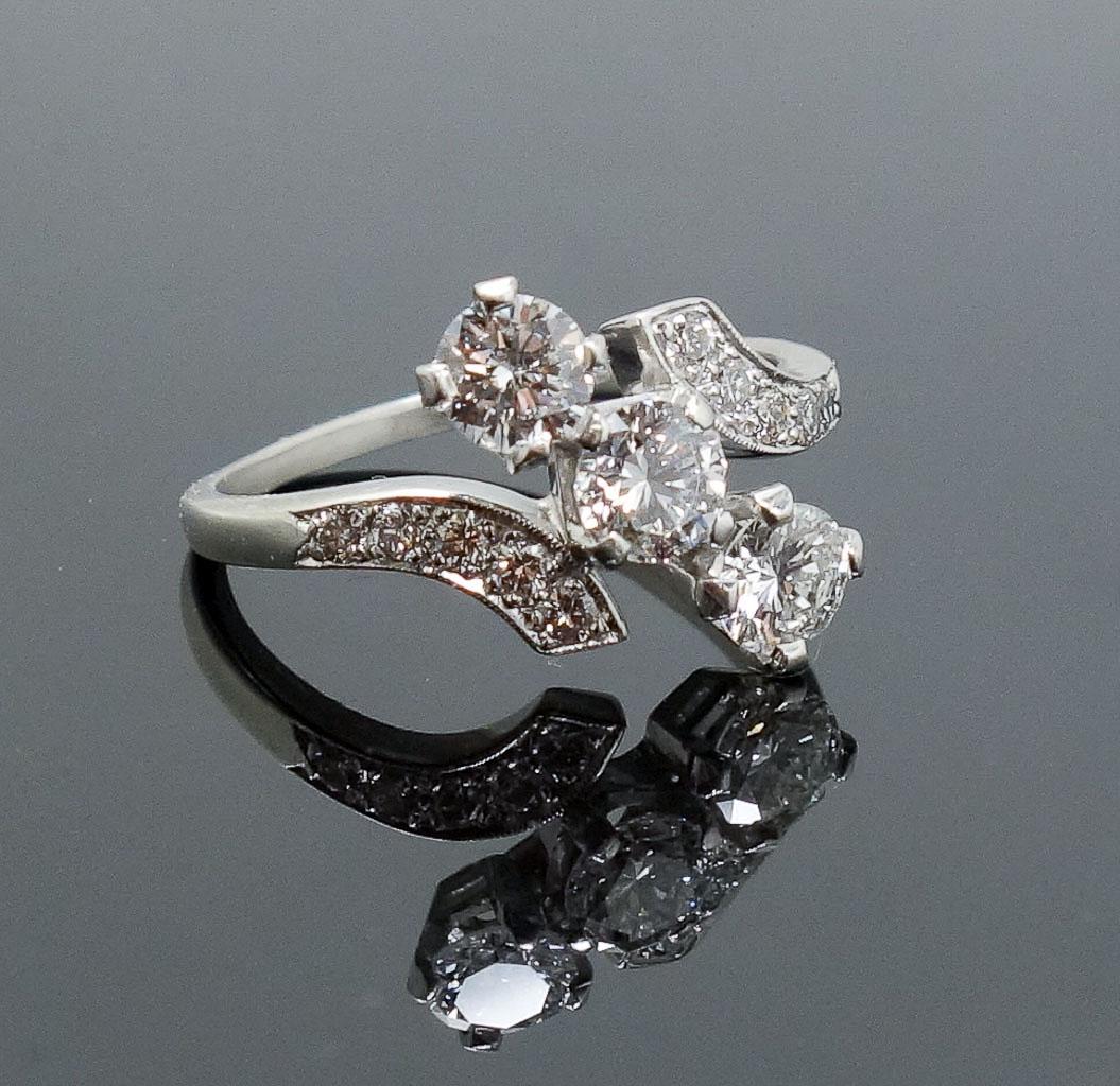 1940s/50s 1.25tcw Triple Diamond Platinum Ladies Ring: This is a stunning estate found vintage ladies ring dating to the 1940s/50s. Rendered in fine platinum, this retro ring features three round brilliant cut diamonds offset between sweeping supports als