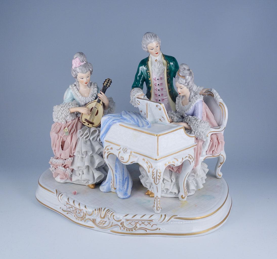 Hoffner W. German Crinoline Porcelain Harpsichord Lute: Charming group of figures playing music together on a harpsichord and lute. It was made in the mid 20th century by Hoffner & Co. in Sandizell, West Germany. Hoffner & Co. was a small family owned busi