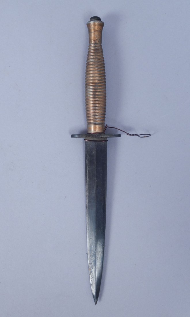 WWII Fairbairn-Sykes Fighting Knife With Sheath #1: This is a thick-bladed, hand-ground, third pattern Fairbairn Sykes commando fighting knife. "England" "I" with 3-point crown stamped on guard of knife, which has a mold marking of 2 at the top of the