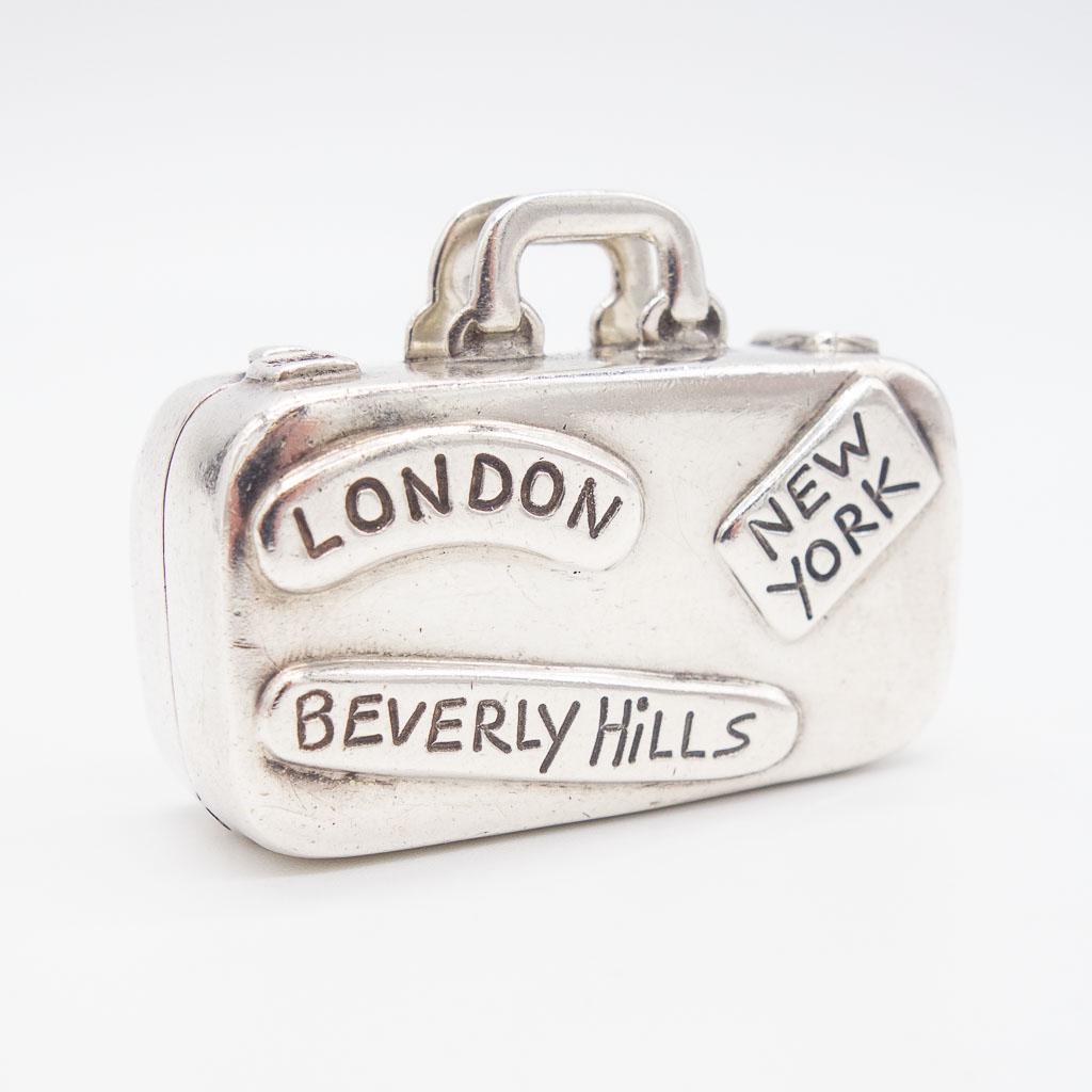 Tiffany Sterling Silver Luggage Suitcase Pill Box: This vintage Tiffany & Co. Philippines travel luggage suitcase pill box is rendered in .925 sterling silver. This suitcase is replete with travel destination labels. It measures 1 5/8 x 1 3/8 x 3/4" a