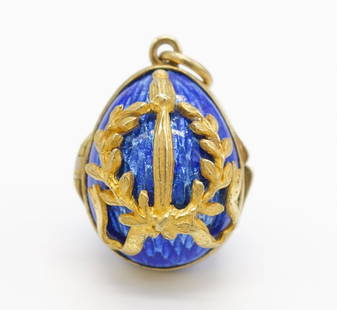 Faberge Style Solid Gold Blue Enamel Egg Charm: This Faberge-style egg charm hinges to open. It features a blue enamel and a laurel leaf motif with ribbons. In 10K gold. This charm measures 1" x 5/8" and weighs 4.9dwt.