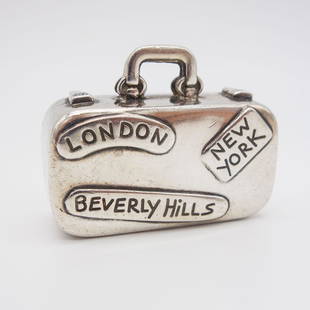 Tiffany Sterling Silver Luggage Suitcase Pill Box: This vintage Tiffany & Co. Philippines travel luggage suitcase pill box. Rendered in .925 sterling silver, this suitcase is replete with travel destination labels. This charm measures 1 5/8 x 1 3/8 x