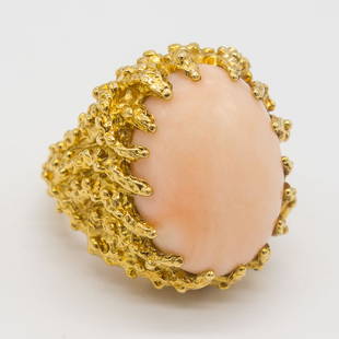 18K Gold Angel Skin Pink Coral Cabochon Ring Size 7: This biomorphic vintage ring is rendered in 18K gold. This heavy setting features a large angel skin coral cabochon. The ring is a size 7, weighs a total of 14.3dwt and the cabochon measures 19.6 x