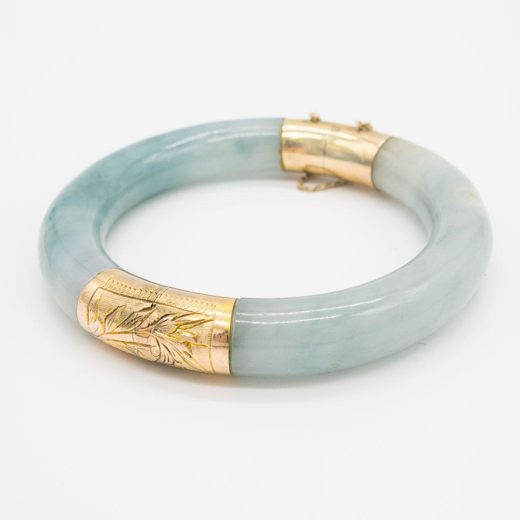 Vintage 14K Gold Green Jadeite Bangle Bracelet: This is a vintage green jadeite bangle bracelet in 14K yellow gold with engraved details. The interior circumference is 7". The bangle width is 11 x 11.8mm. The total weight is 45.0dwt.