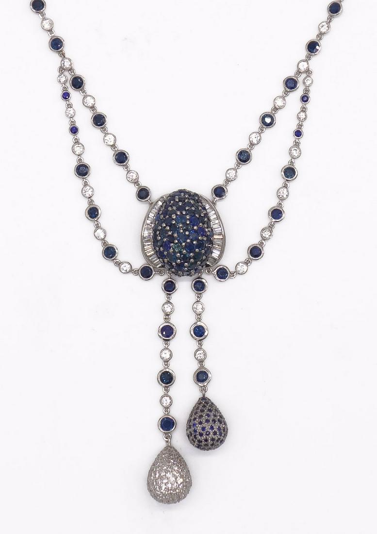 14K Sapphire and Diamond Tassel Pendant Necklace: This bezel set alternating sapphire and diamond station necklace in 14K white gold is centered by a domed pave sapphire form flanked by channel set baguette diamonds. Two teardrop shaped tassels, with