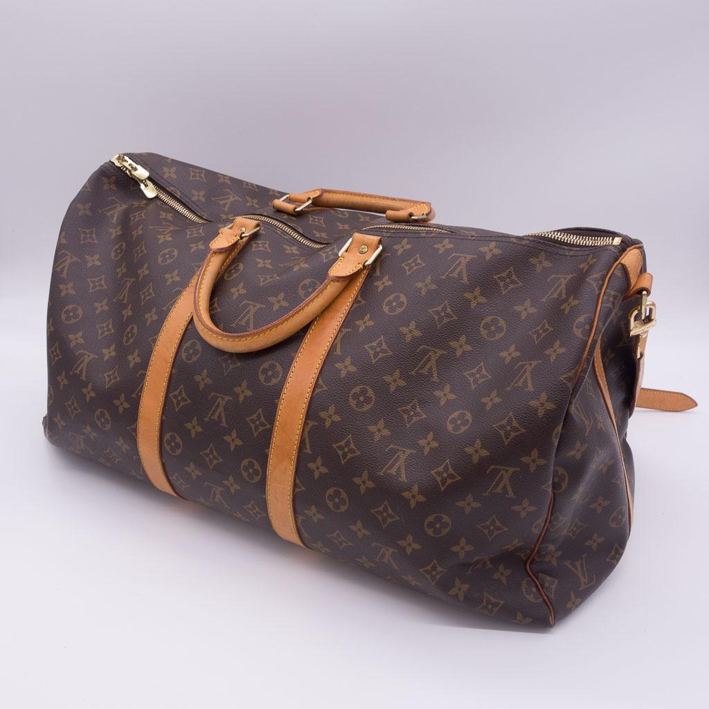Louis Vuitton Keepall Bandouliere 55 Travel Duffle Bag: This Louis Vuitton Keepall Bandouliere 55 bag is a travel duffle style. It features the iconic brown monogram canvas with leather trim and brass hardware. It measures 21.7" x 12.2" x 9.4" and weighs 1