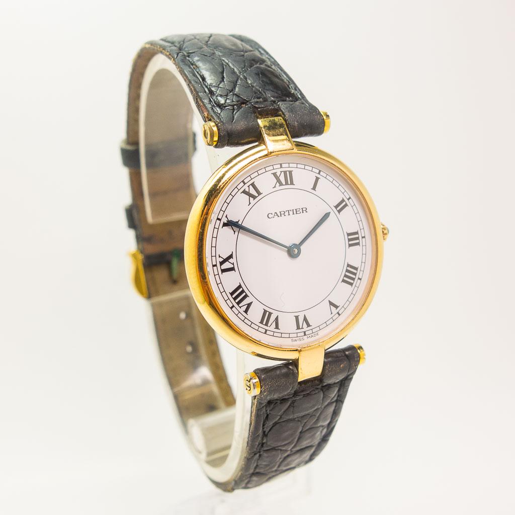 Cartier Vendome 18K Yellow Gold Wristwatch: This Cartier Vendome quartz watch is made in 18K yellow gold. It features round 30mm case, white Roman dial, and a black leather strap with buckle. The reference number for this watch is 881001 and th