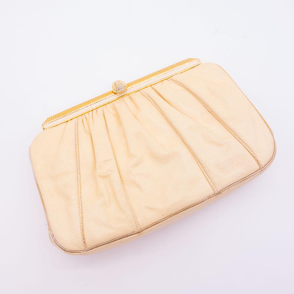 Judith Leiber Clutch Handbag with Box: This Judith Leiber clutch bag is a buttercream yellow color with a lizard skin pattern and gold-tone findings. On the interior of the bag is a gold-tone mirror and chain strap. 8.75" (W) x 5.5" (H) x