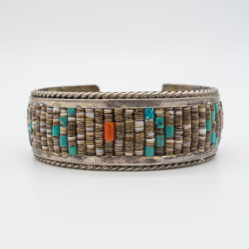 Navajo Pawn DJ Clark Sterling Silver Turquoise Bracelet: This is a Native American Navajo cuff bracelet signed D&J Clark. Rendered in sterling silver, this bracelet features shell, turquoise, and coral beaded details. The interior circumference is 5 3/8" lo