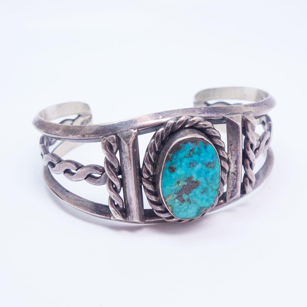 Native American Pawn Silver Braid Motif Turquoise Cuff: This is a Native American cuff bracelet rendered in sterling silver. This cuff features a charming braided motif and turquoise cabochon. The interior length is 5 1/4" long plus a 1 1/4" gap at the bac