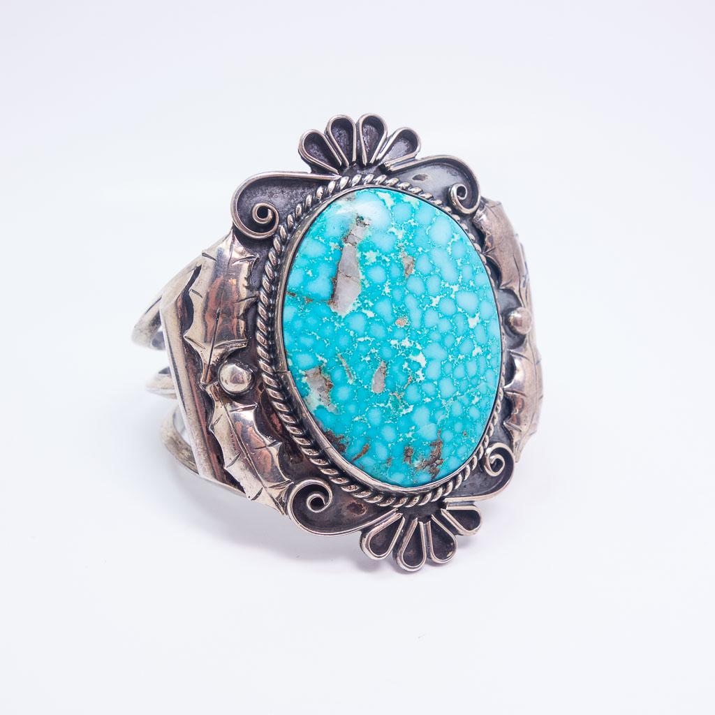Native American Pawn Silver Leaf Motif Turquoise Cuff: This is a vintage Native American pawn cuff bracelet rendered in sterling silver. This cuff features leaf and berry motif designs framing a large turquoise cabochon. The interior length of the cuff is