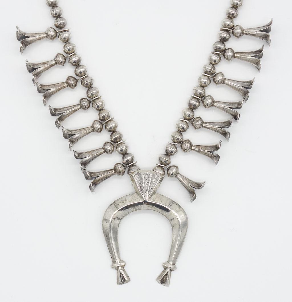 Native American Pawn Silver Squash Blossom Necklace: This is a Native American pawn Navajo necklace. Rendered in sterling silver, the bold squash blossom necklace features an inverted crescent (naja) pendant. It is 24" long. The pendant is 3 1/4" x 2 3/