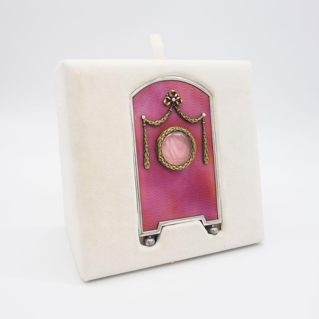 Theo Faberge Sterling Silver Frame Pink Enamel Pearl: This lovely Theo Faberge picture frame is made in sterling silver with a pink enamel guilloche pattern and pearl accents. The round portion that holds a picture hinges open. The frame is 4 1/2" x 2 5/