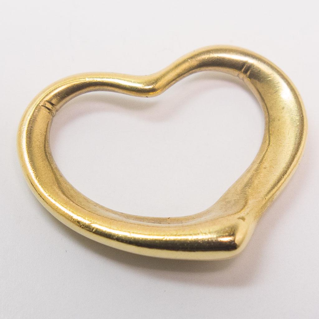 Small 18K Gold Elsa Peretti Tiffany Open Heart Pendant: This is an estate found Tiffany & Co. necklace pendant designed by Elsa Peretti. Rendered in 18K yellow gold, this pendant is part of the "Open Heart" collection. This pendant measures 22mm x 17.6mm. 